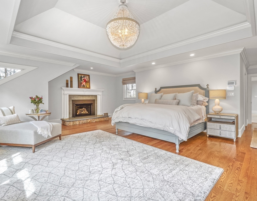 119 Lincoln Road Wayland, MA 01778 - Photo 19 of 40 a spacious bedroom with a large bed and a fireplace