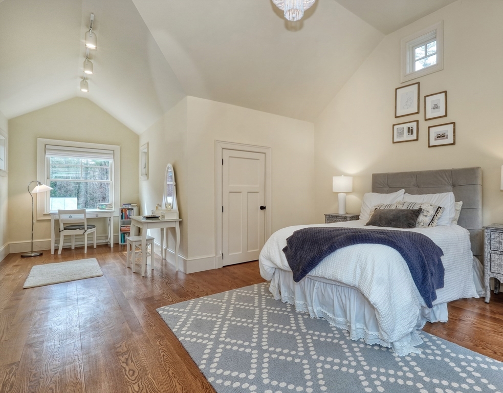 119 Lincoln Road Wayland, MA 01778 - Photo 28 of 40 a bedroom with a bed a table and three large mirror with wooden floor