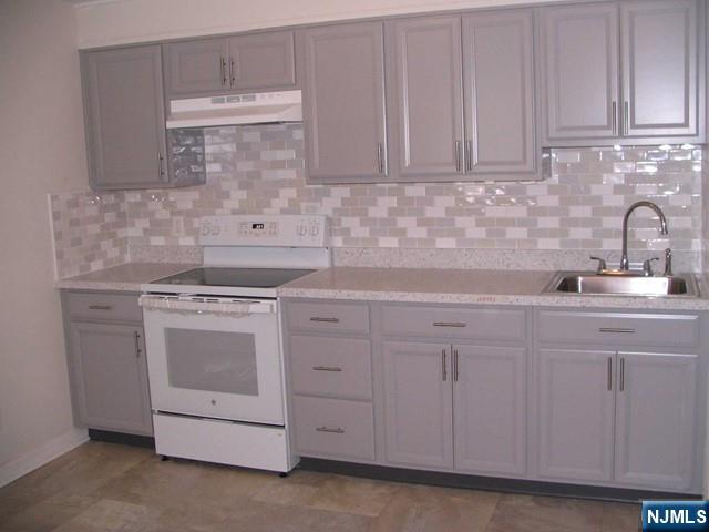 a kitchen with white cabinets and sink