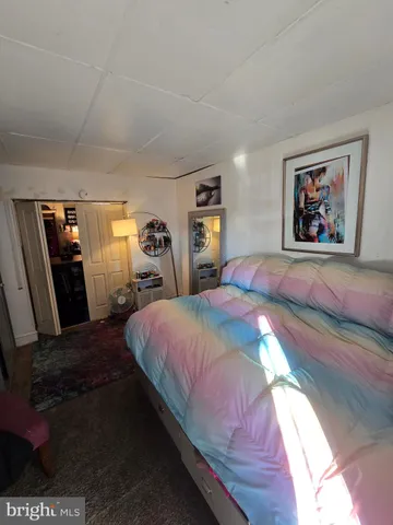 a bedroom with a bed and a painting on the wall