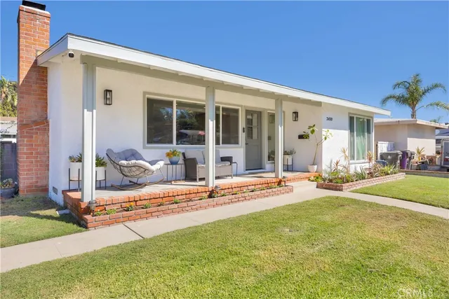 a view of a house with backyard and sitting area