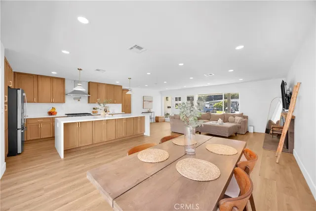 a large kitchen with white cabinets stove top oven and couches
