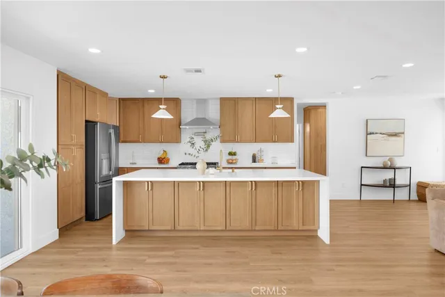 a large white kitchen with a refrigerator a counter top space and cabinets