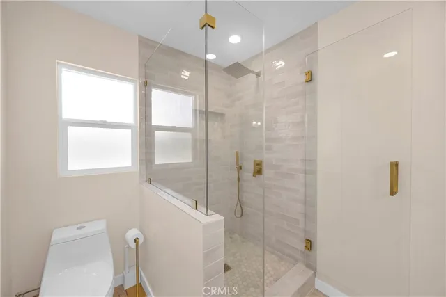 a bathroom with a shower a toilet and sink