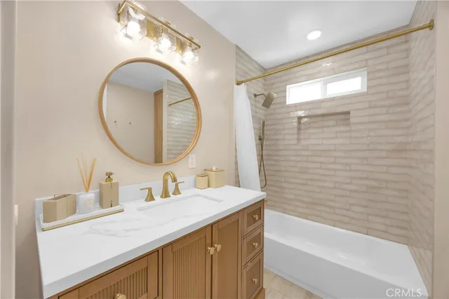 a bathroom with a sink vanity mirror and a bathtub