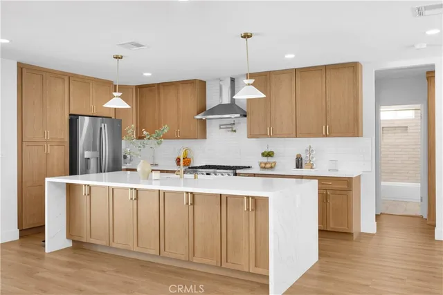 a kitchen with stainless steel appliances a stove refrigerator sink and cabinets