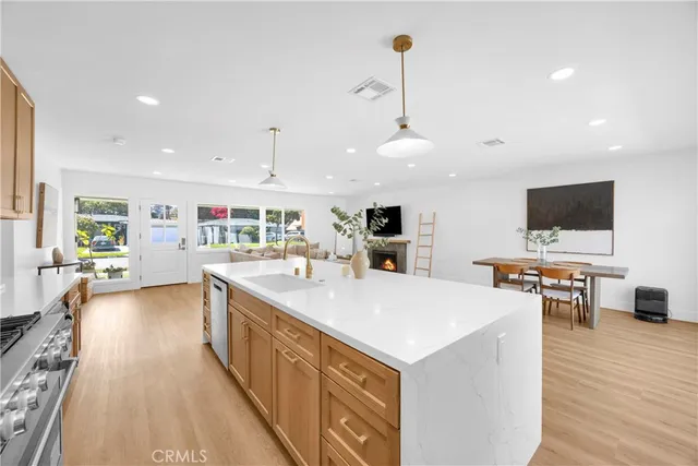 a large kitchen with a large counter top appliances and wooden floor