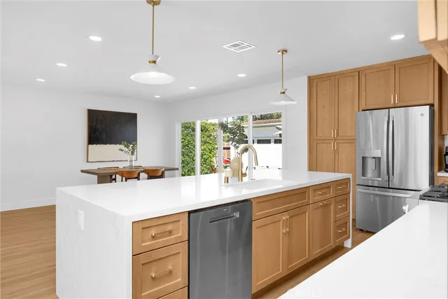 a kitchen with stainless steel appliances a sink stove and refrigerator