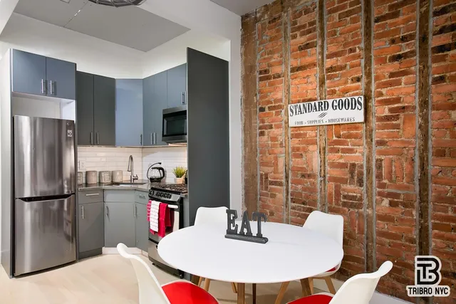 a kitchen with a refrigerator and a dining table