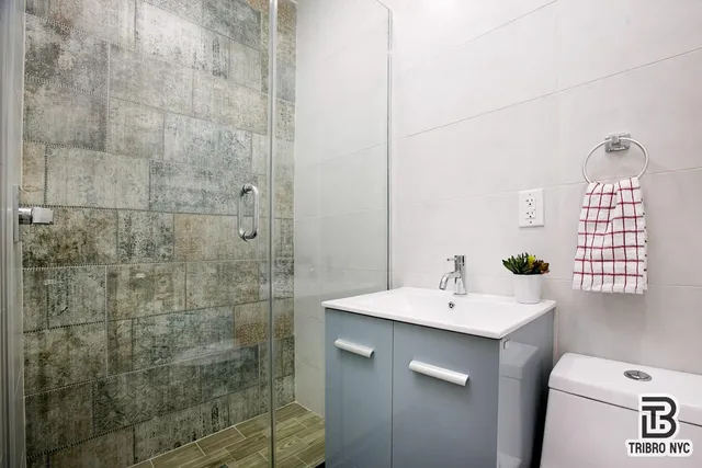 a bathroom with a sink a toilet and shower