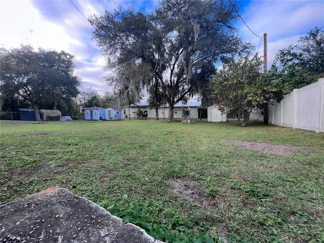 a view of a field with trees in the background