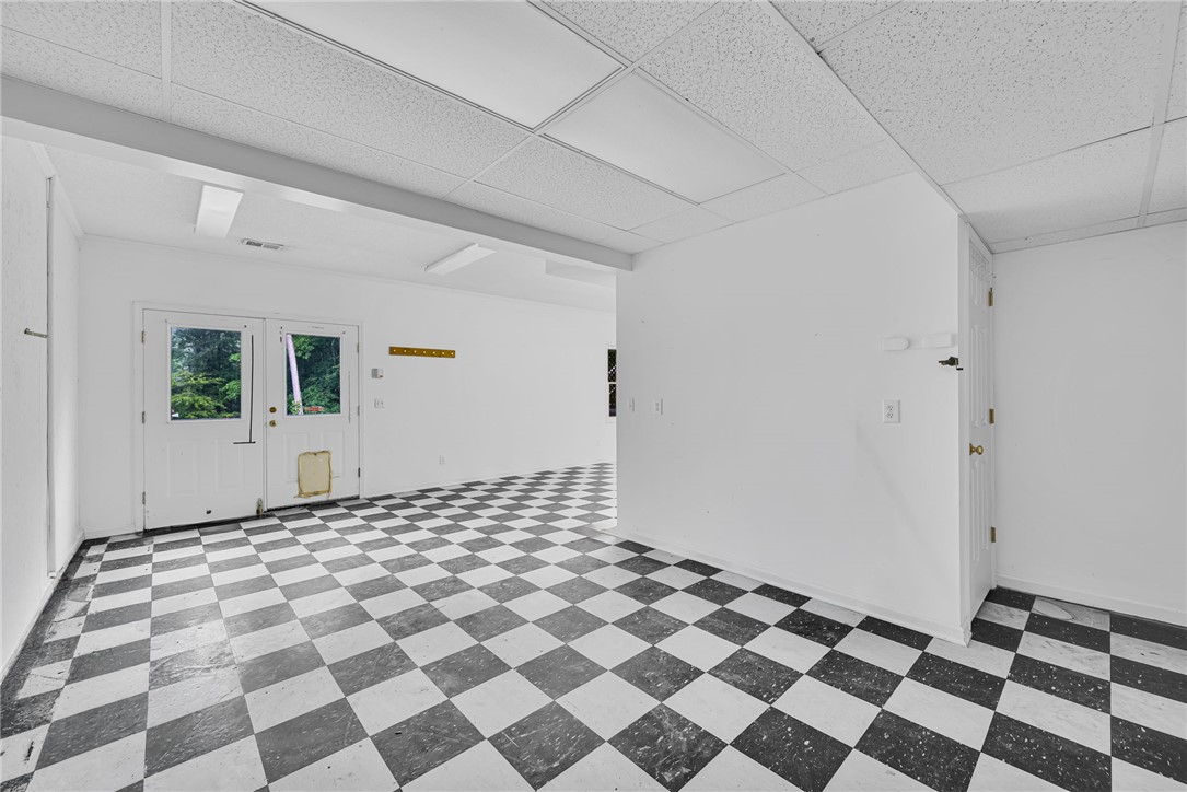 1016 Campbell Road Belton, SC 29627 - Photo 26 of 50 Bold checkered flooring defines this versatile space with direct outdoor access, ready for diverse uses.