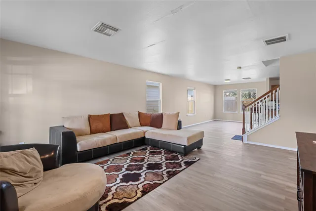 a living room with furniture and wooden floor
