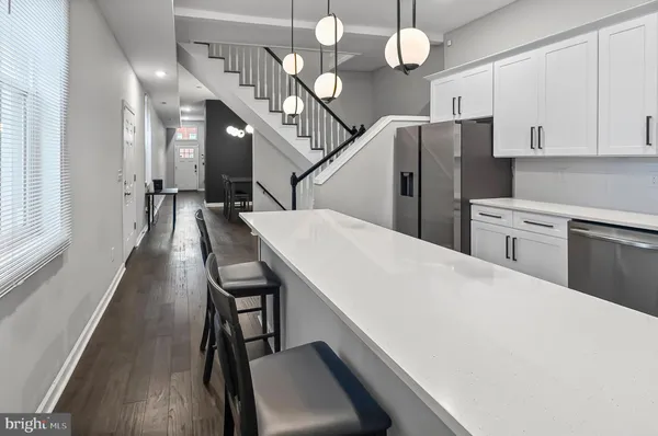 a view of a kitchen with furniture and stainless steel appliances