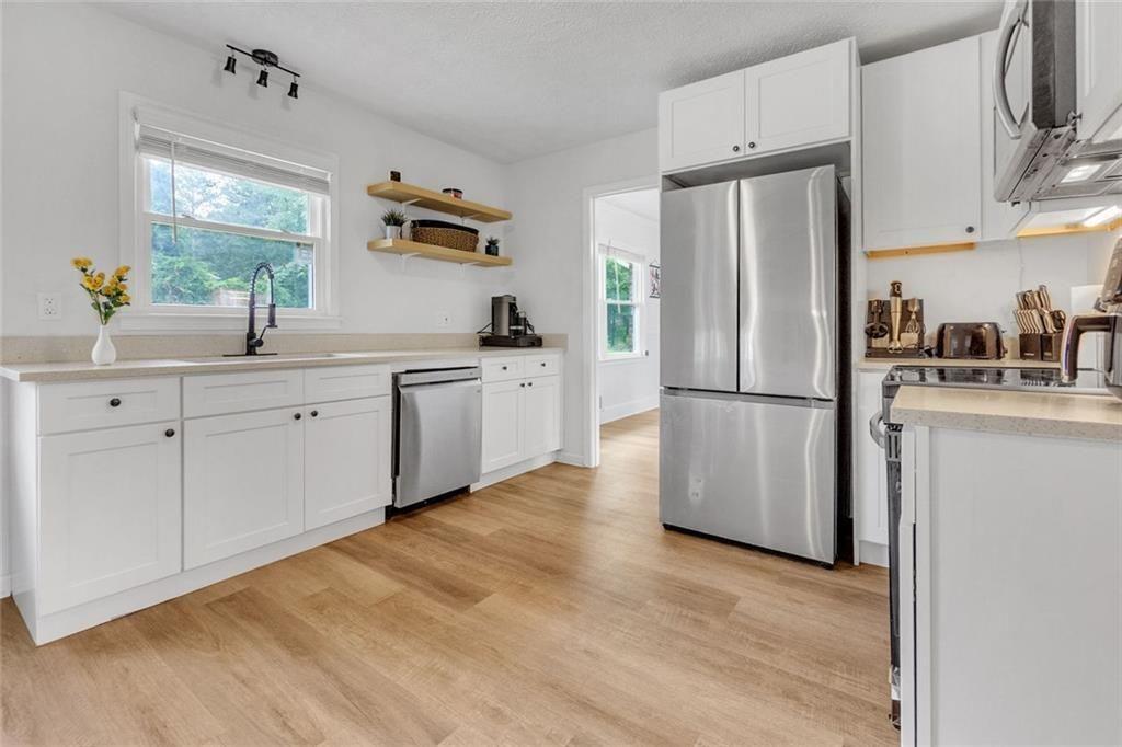 5800 Cedar Lane Southwest Mableton, GA 30126 - Photo 22 of 41 a kitchen with stainless steel appliances a refrigerator sink and cabinets
