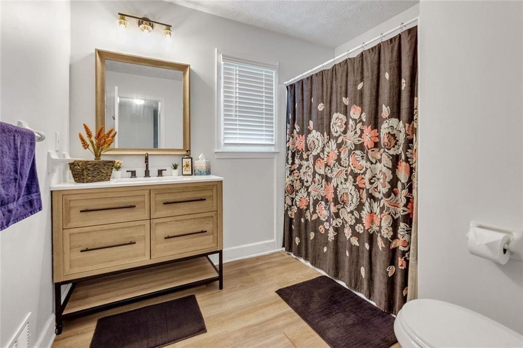 5800 Cedar Lane Southwest Mableton, GA 30126 - Photo 29 of 41 a bathroom with a sink a toilet and shower curtain
