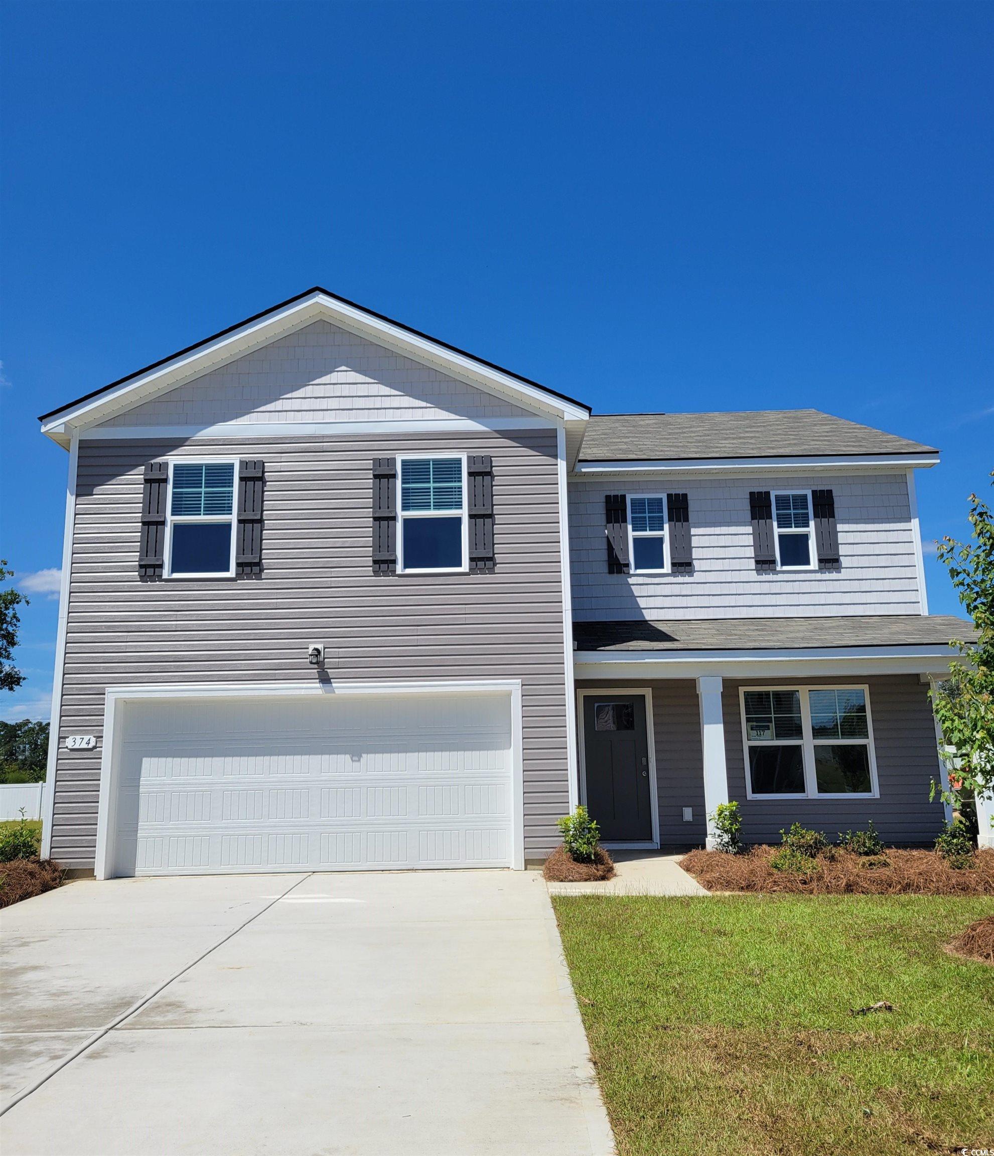 View of front of property with an attached garage, driveway, and a front yard