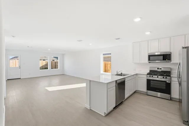 a kitchen with stainless steel appliances granite countertop a stove and a sink