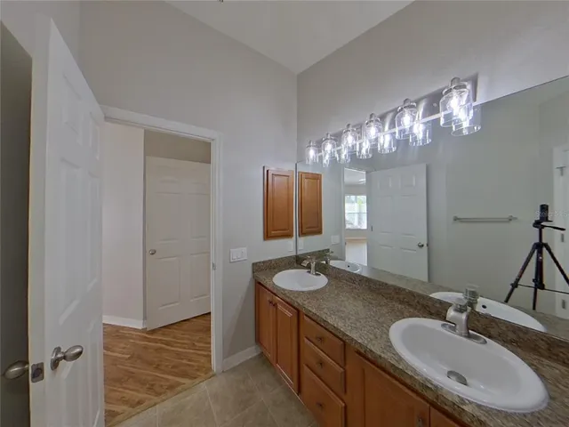 a bathroom with double vanity sinks and a mirror