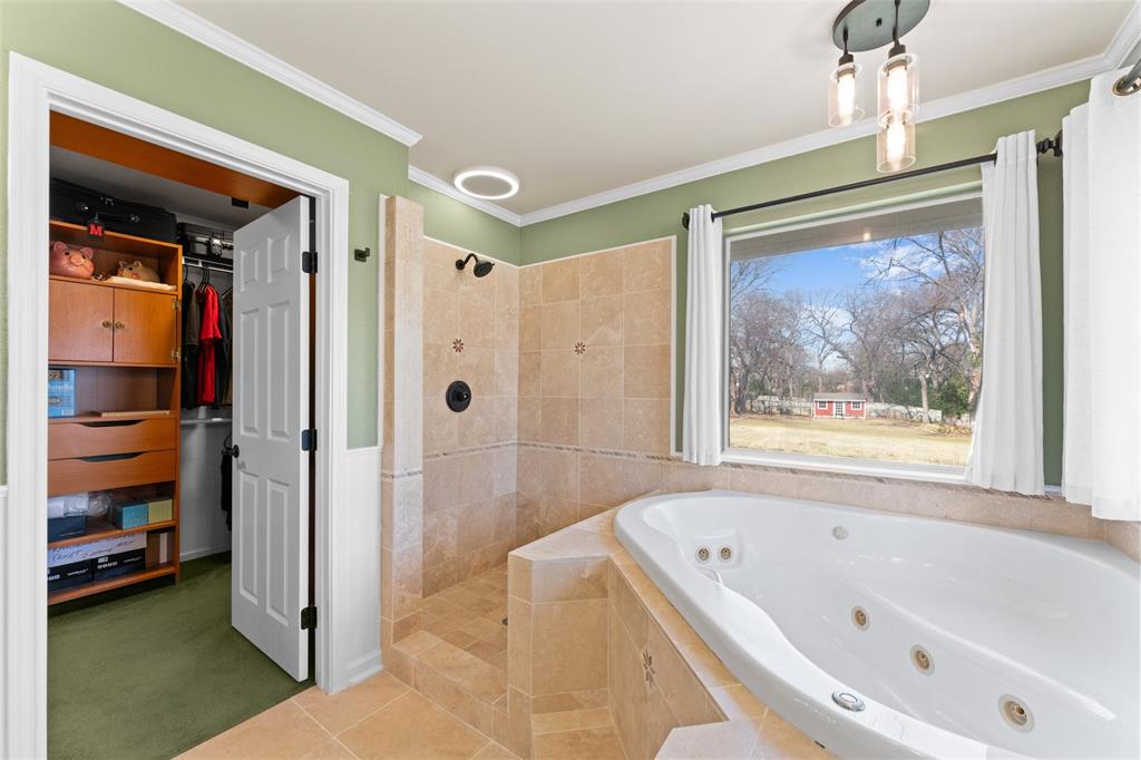 805 East Shady Grove Road Irving, TX 75060 - Photo 16 of 36 Full bathroom with walk in shower, a tub with jets, a spacious closet, ornamental molding, and tile patterned flooring