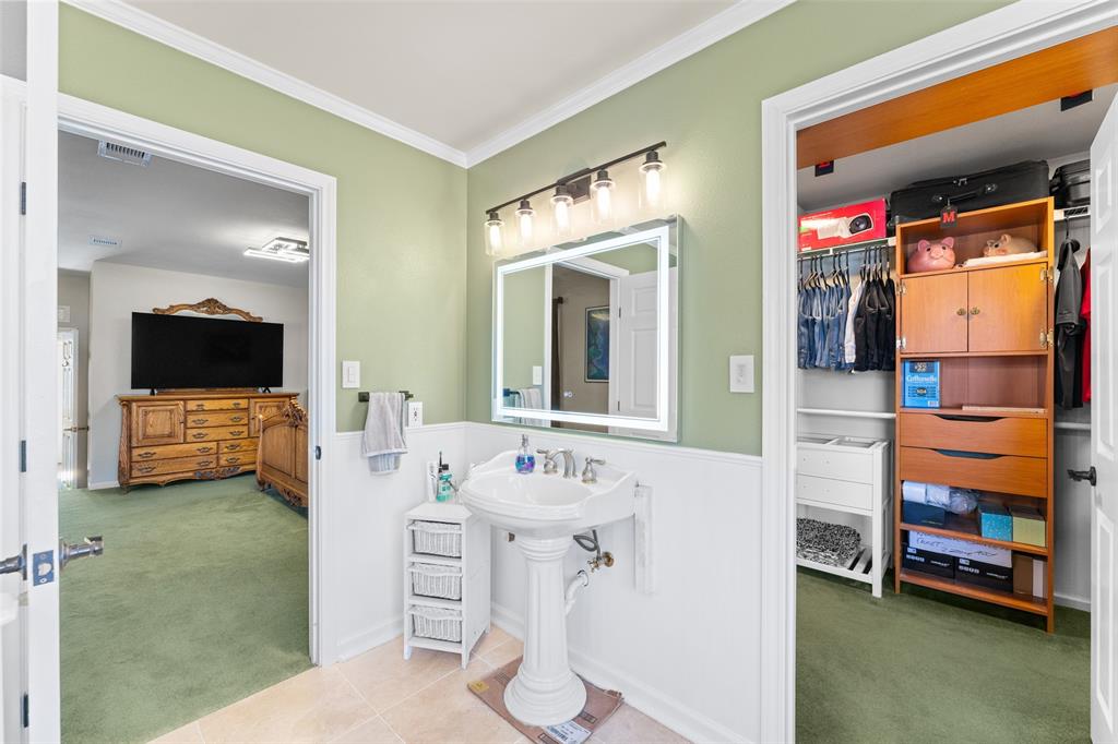 805 East Shady Grove Road Irving, TX 75060 - Photo 17 of 36 Bathroom with a walk in closet, ornamental molding, tile patterned flooring, and wainscoting