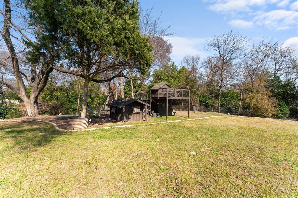 805 East Shady Grove Road Irving, TX 75060 - Photo 28 of 36 View of 1.6 acre yard featuring an outbuilding and view of wooded area