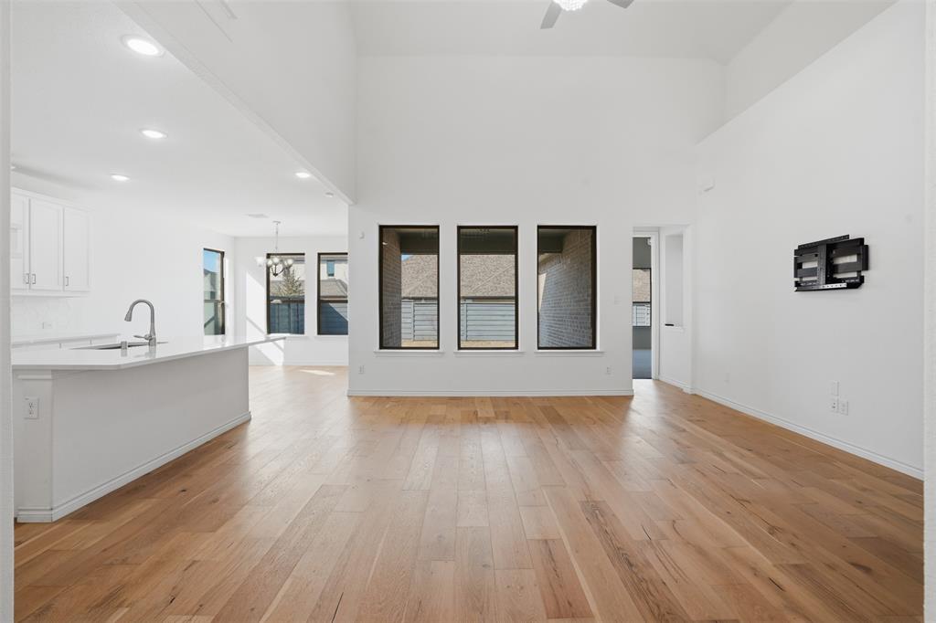 537 Oakmoss Street Little Elm, TX 76227 - Photo 11 of 39 a view of an empty room with wooden floor and a window