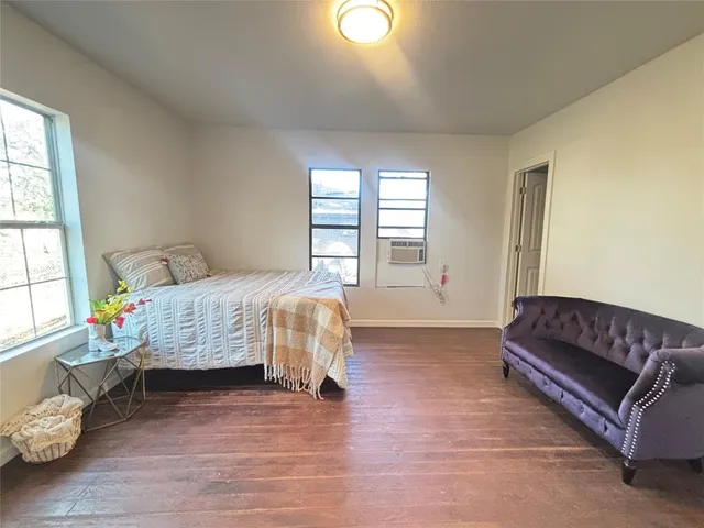 a bedroom with a bed couch and a window