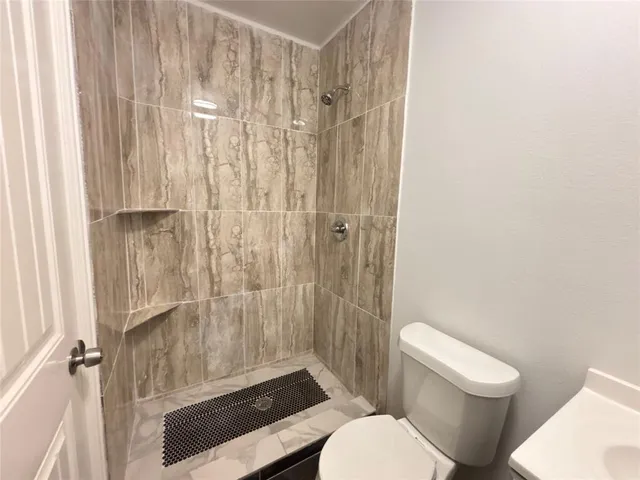 a white toilet sitting next to a shower curtain