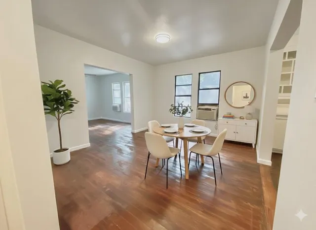 a living room with furniture a window and wooden floor