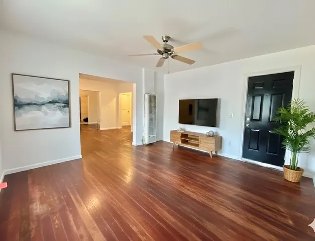 a view of a livingroom with wooden floor and a flat screen tv