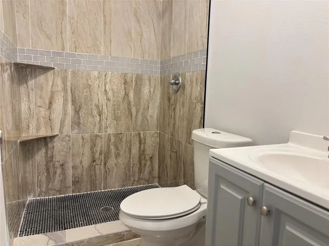 a bathroom with a sink a toilet and a shower