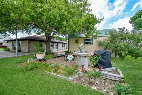 a view of a house with backyard sitting area and garden