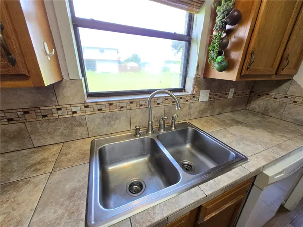a kitchen with stainless steel appliances granite countertop a sink a stove and a refrigerator