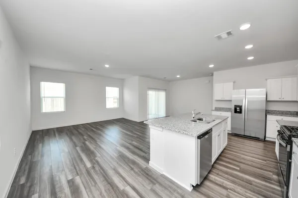 a kitchen with a stove a sink and a refrigerator