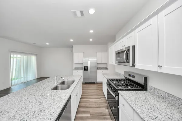 a kitchen with stainless steel appliances granite countertop a stove and a sink