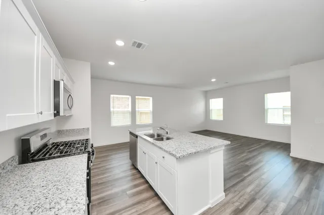a kitchen with a sink stove and cabinets
