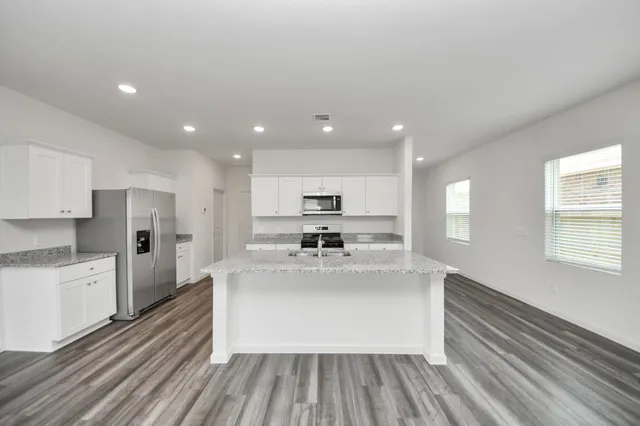 a large white kitchen with stainless steel appliances