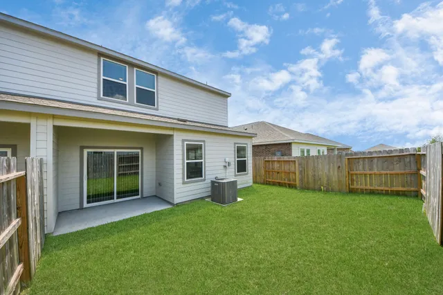 a view of a house with a yard and a large tree