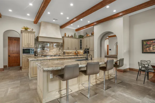 a kitchen with stainless steel appliances kitchen island granite countertop a table and chairs in it