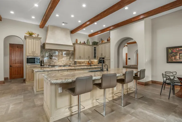 a kitchen with stainless steel appliances kitchen island granite countertop a table and chairs in it
