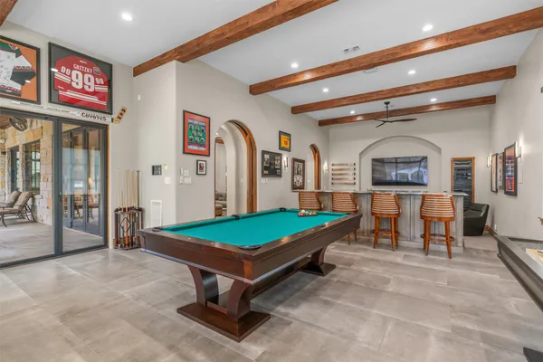 a living room with furniture pool table and paintings on the wall