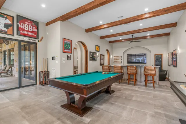 a living room with furniture pool table and paintings on the wall