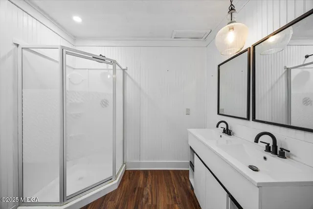 a bathroom with a sink a mirror a vanity and shower