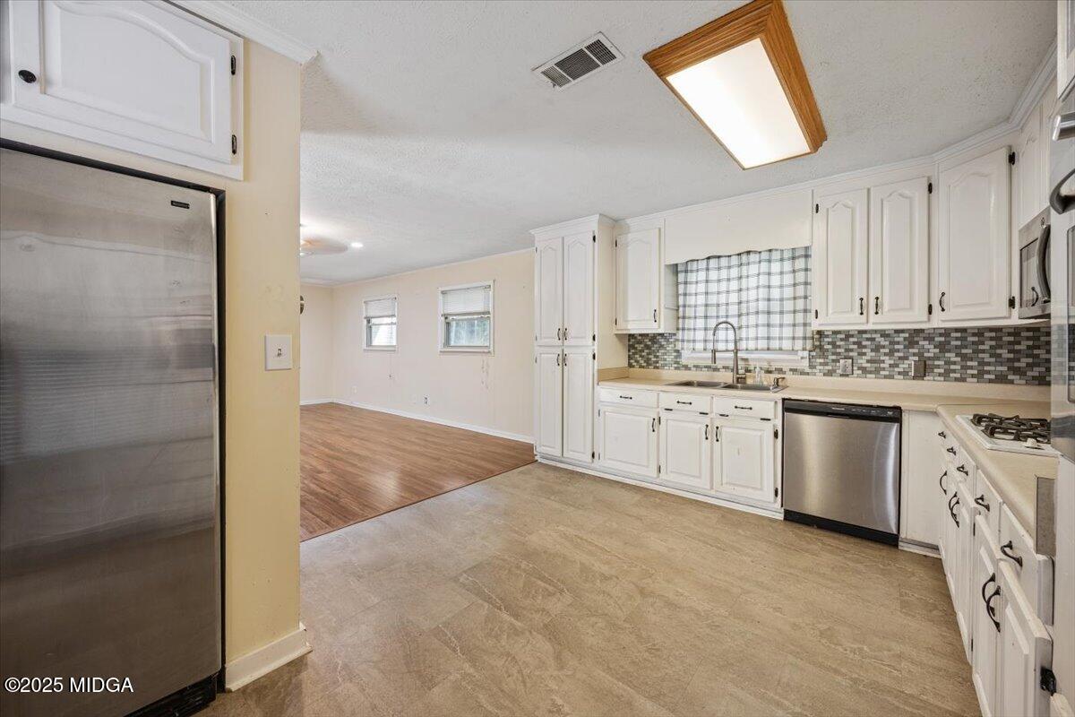 143 Ragan Drive Gray, GA 31032 - Photo 4 of 19 a kitchen with granite countertop white cabinets and white appliances