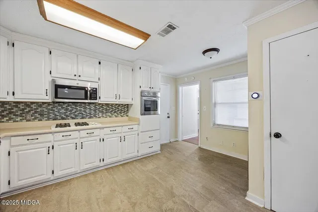 a spacious bathroom with stainless steel appliances granite countertop a refrigerator and a sink