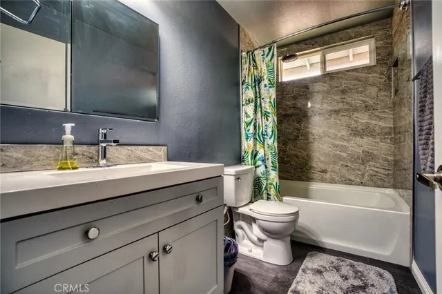 a bathroom with a bathtub shower sink vanity mirror and toilet