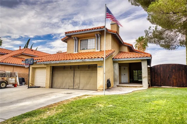 a view of a white house with a yard and garage