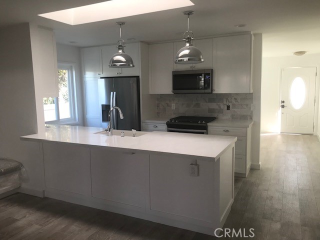 29095 Madrid Road Laguna Niguel, CA 92677 - Photo 10 of 36 a kitchen with a sink a microwave a refrigerator and wooden floor