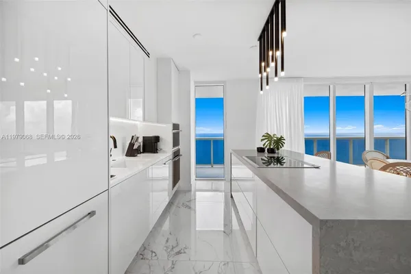 a kitchen with stainless steel appliances granite countertop a sink a refrigerator and a refrigerator
